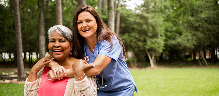 A nurse and a senior lady smiling